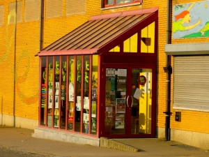 Vue de l'entrée vitrée, en décrochage par rapport à la façade de briques jaunes.